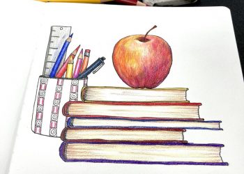 Back to school supplies stacked books, pencils and pen in a cup and an apple on top of the books